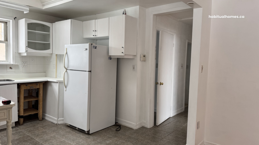 Original kitchen before demolition — old cabinets and appliances in 1950s Toronto home
