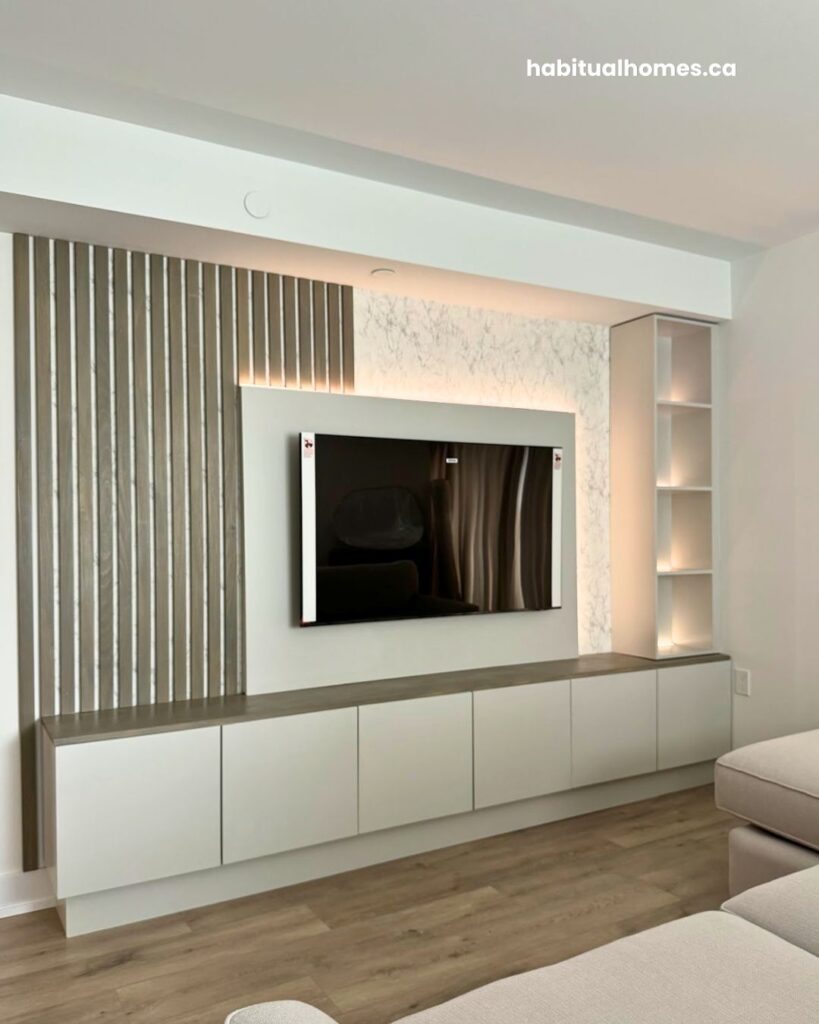 Custom media wall in a Bloor East Toronto condo viewed from the bedroom, showing integrated LED lighting and built-in storage