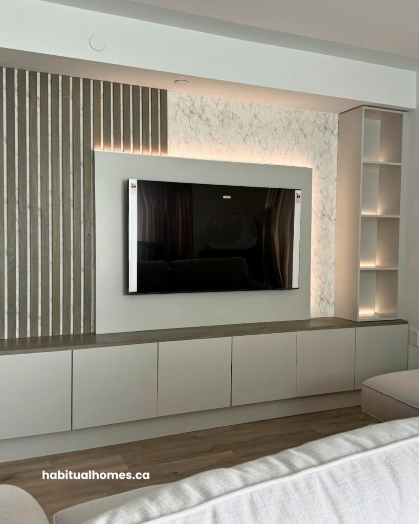 Side view of custom media wall with TV, vertical poplar slats, and built-in storage in a Bloor East Toronto condo